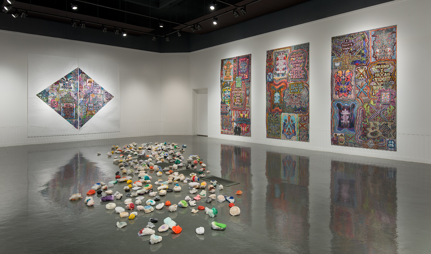 large art gallery with color art pieces on floor and wall